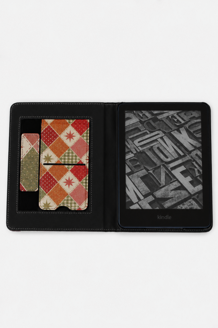 A black Kindle e-reader shown open in a folio-style case, with patterned card slots on the left and a grayscale book cover on the right. The Kindle brand name is visible at the bottom of the screen.