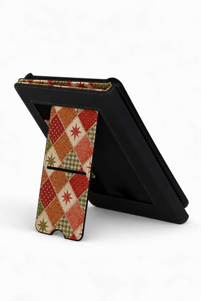 A black tablet case with a built-in kickstand, shown standing open on a white background. The front cover features a vintage-style argyle pattern in red, orange, green, and beige.