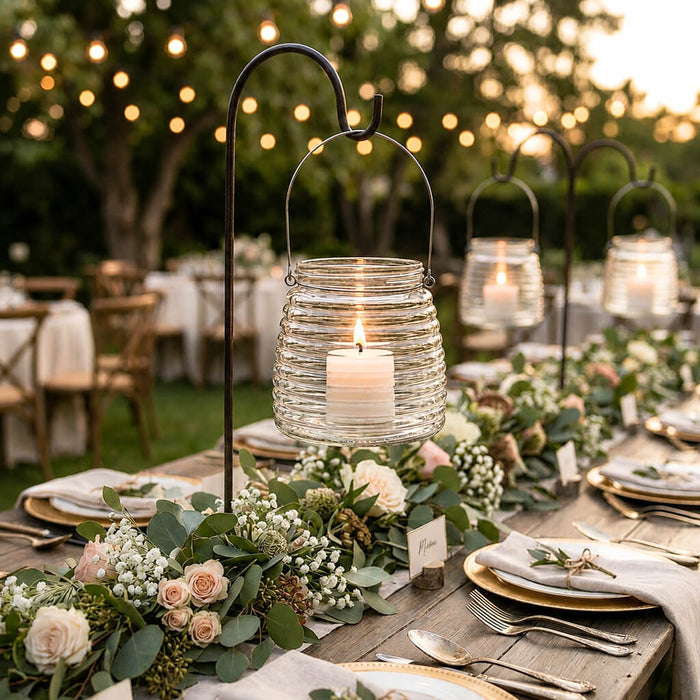 4.6" Hanging Horizontal Ribbed Glass Jar with Handle holding a candle on a garden table