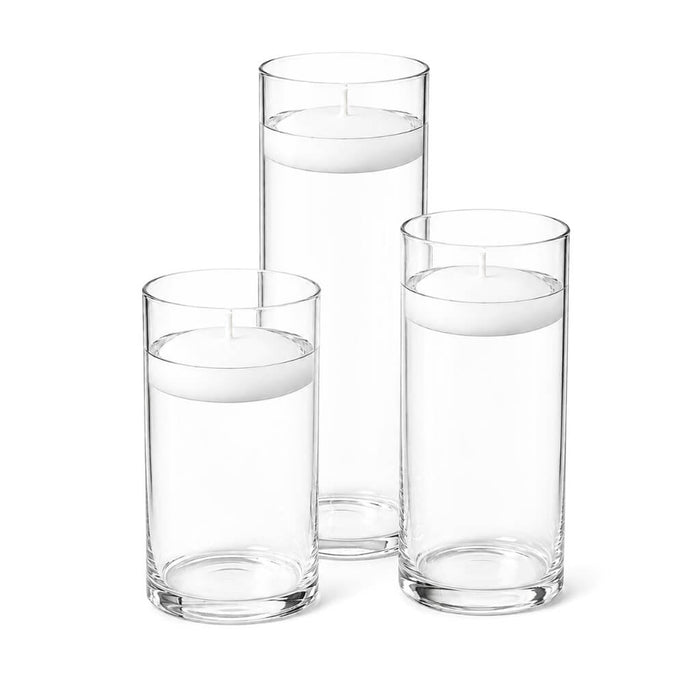 Three white floating candles in cylindrical glass vases filled with water