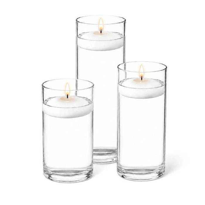 Cylinder vases filled with water and lit floating white candles
