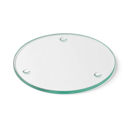 A Round Coaster 4" made of clear glass  against a plain white studio backdrop