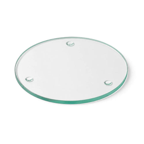 A Round Coaster 4" made of clear glass  against a plain white studio backdrop