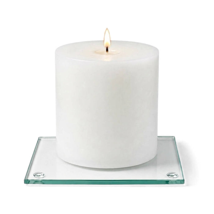 A clean product studio shot of a lit white candle on a clear glass Square Coaster 4"