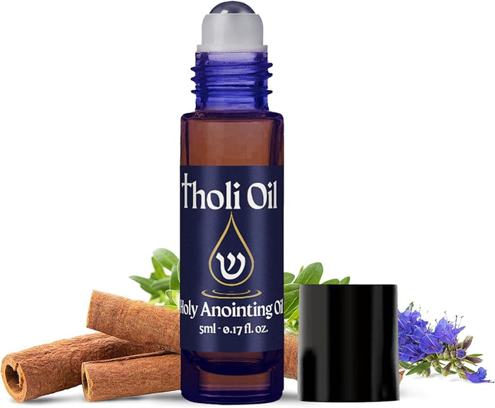 Blue roller bottle labeled 'Holy Anointing Tholi Oil' with cinnamon sticks and flowers on a white background