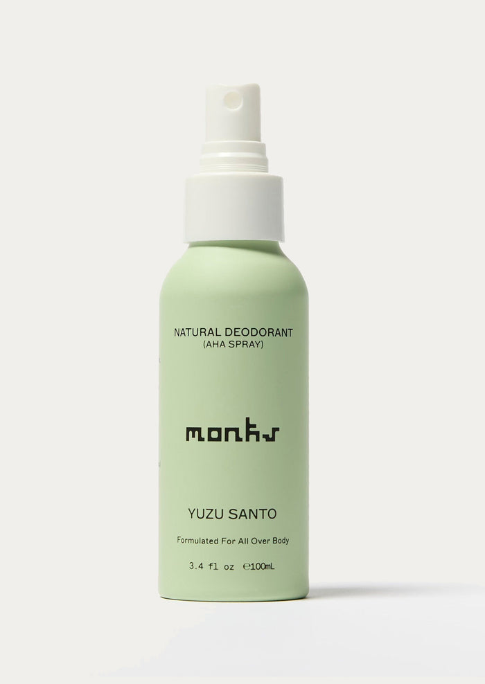 Green deodorant spray bottle with white cap on a light gray background