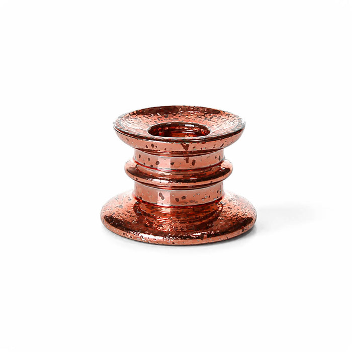 A rose gold tapered candle holder with a speckled finish