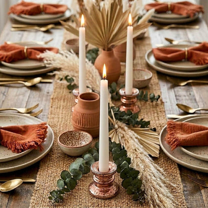 Rose gold taper candle holders with lit white candles on a rustic dining table