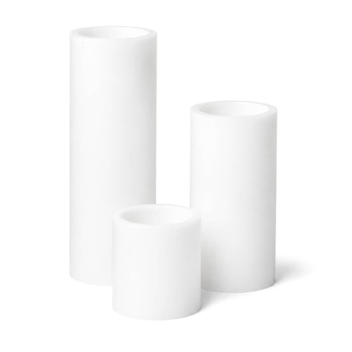 Set of three white LED pillar candles on a white background