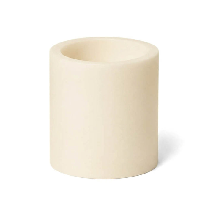 A short ivory flameless LED pillar candle on a white background