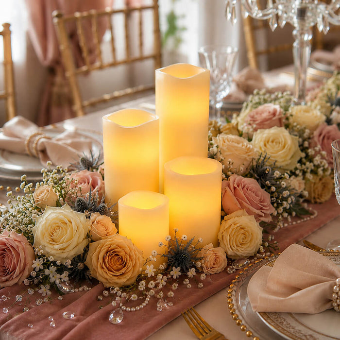 Assorted white flameless candles with warm glow and rose centerpiece