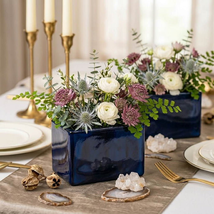 Navy blue square vases styled as wedding centerpieces with white and mauve flowers