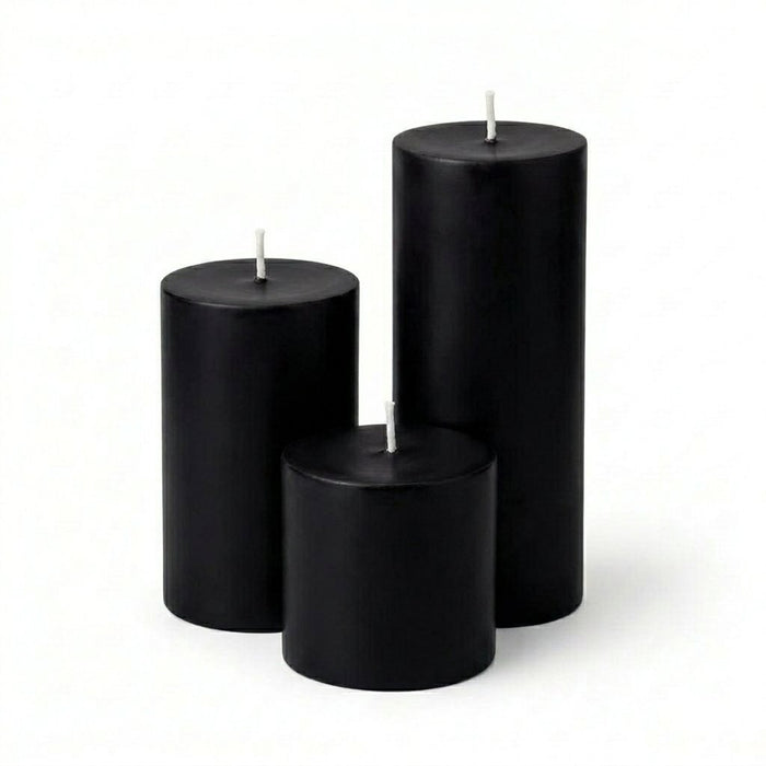 Three black candles of different sizes on a white background