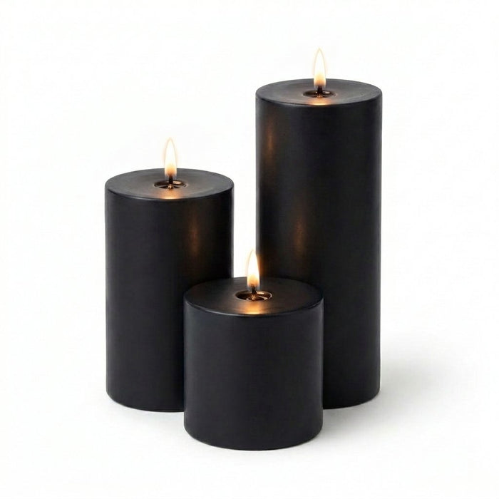Three black candles of different sizes on a white background