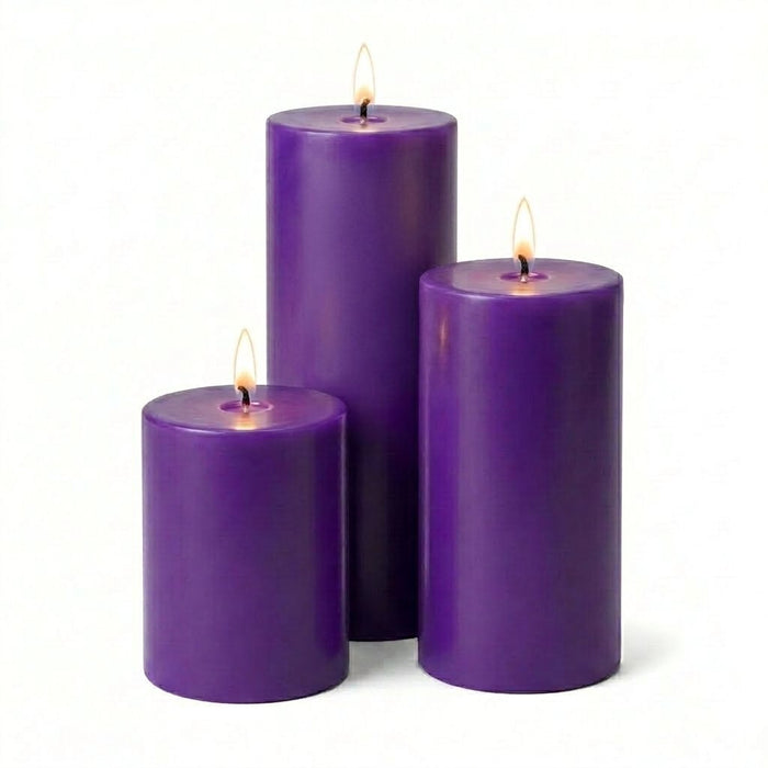 Three lit purple pillar candles in varied heights on a solid white background