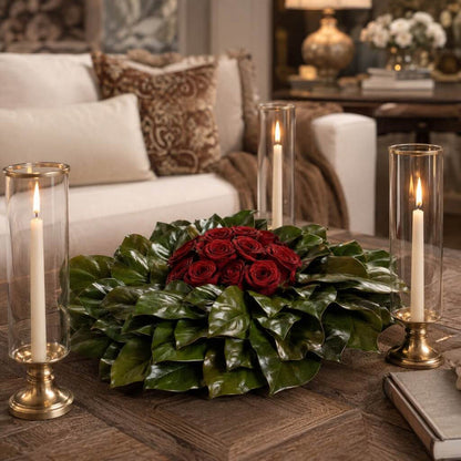 Red roses on magnolia wreath with glass candle holders