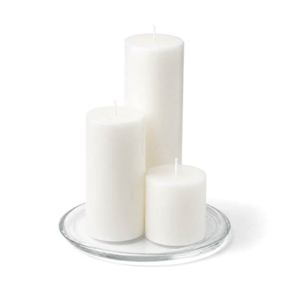 8" Round Glass Pillar Plate with three white pillar candles on a white background