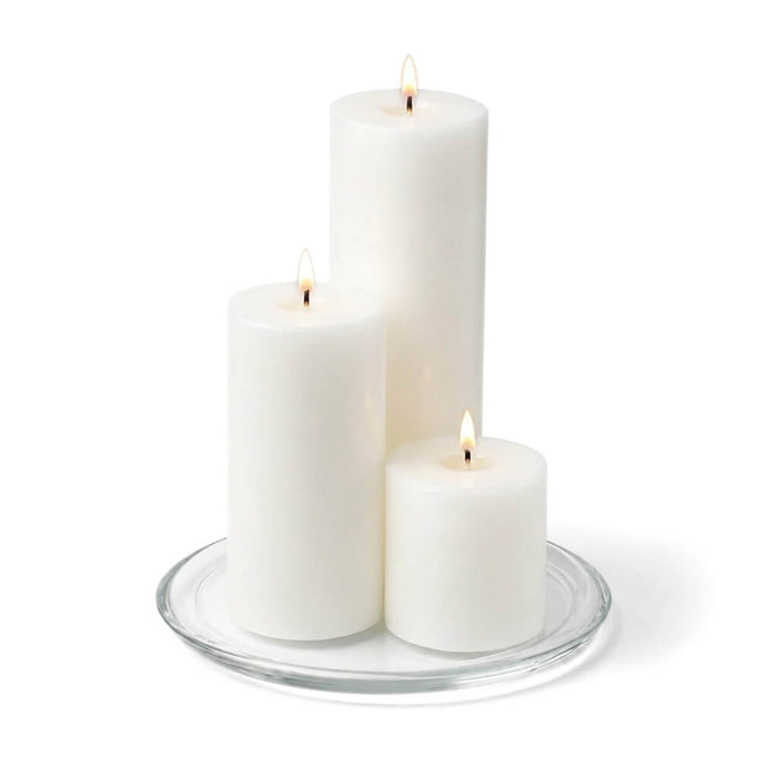 8" Round Glass Pillar Plate with three lit pillar candles on a white background