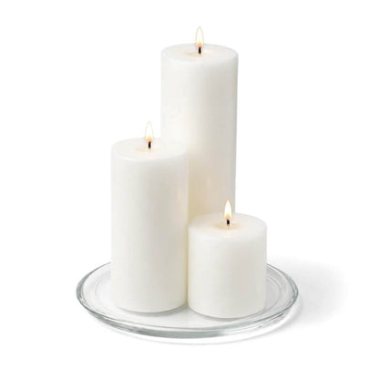 8" Round Glass Pillar Plate with three lit pillar candles on a white background