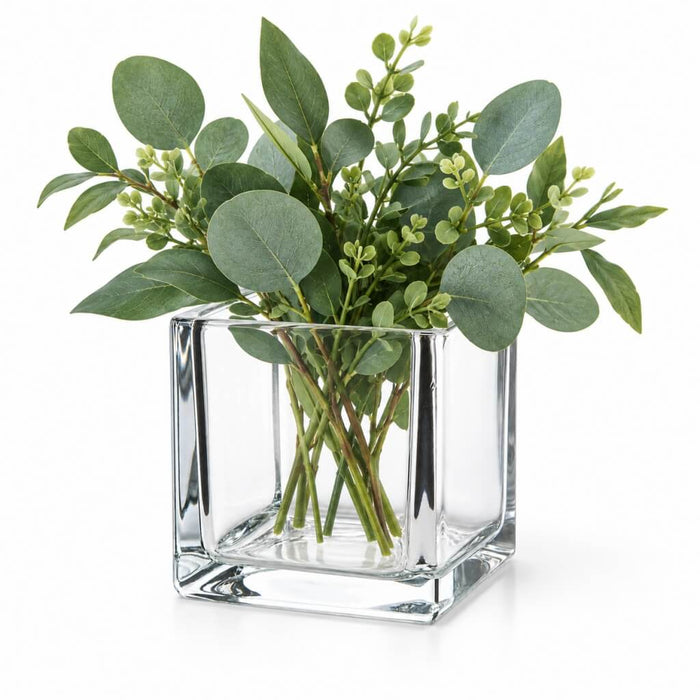 A 4" square glass cube vase filled with lush green eucalyptus branches on a white background
