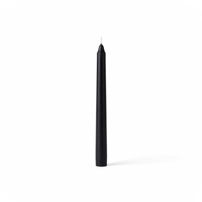 Single black taper candle on clean white backdrop