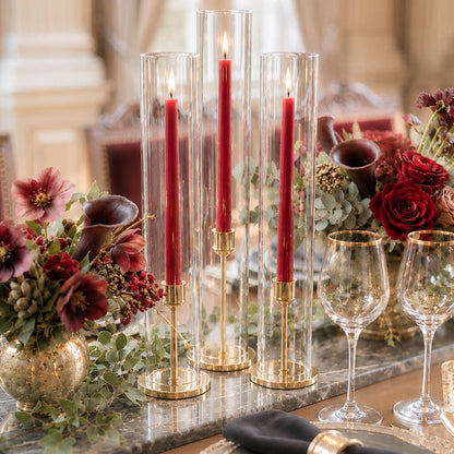 Red taper candles in glass hurricane holders with elegant floral centerpiece