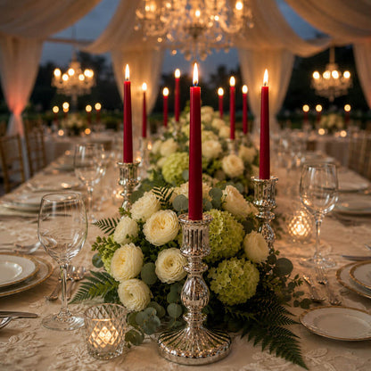 Red taper candles with lush floral decor on formal reception table