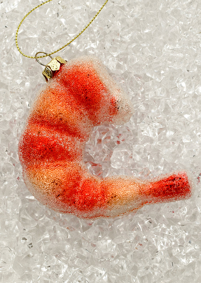 A holiday ornament of a large piece of shrimp.